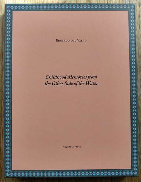 The photography book cover of Childhood Memories from the Other Side of the Water by Eduardo del Valle. Hardback orange book inside clamshell black box.
