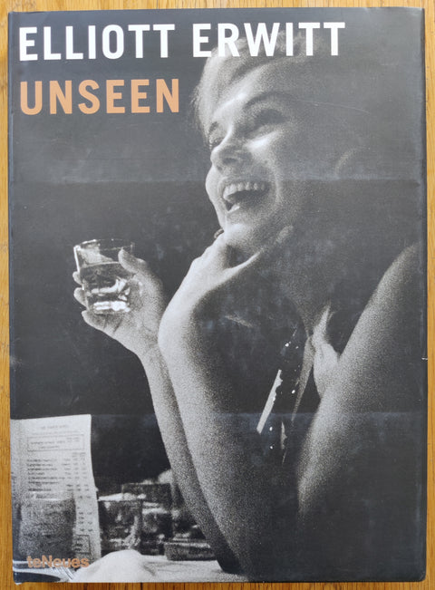 The photography book cover of Unseen by Elliott Erwitt. In dust jacketed  hardcover black. Signed by Erwitt to title page.