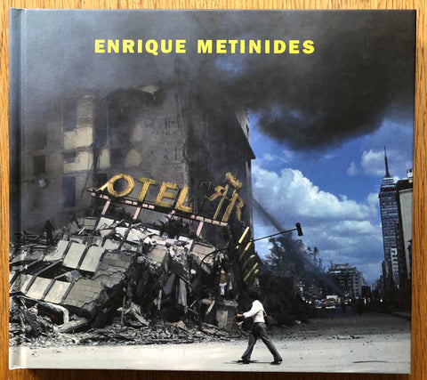 The photography book cover of Enrique Metinides. Hardback with yellow author title and image of a demolished hotel.