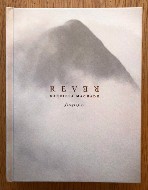 The photography book cover of Rever by Gabriela Machado. Hardback black and white image of cloudy mountain.