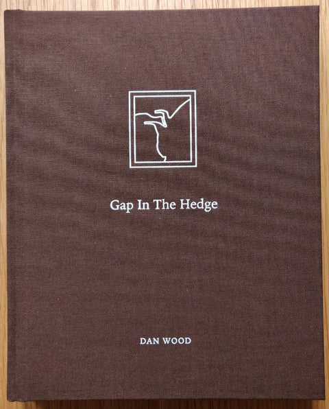 The photography book cover of Gap in the Hedge by Dan Wood. Hardback in brown.
