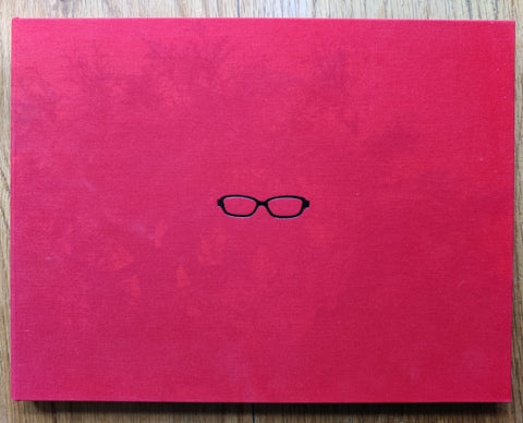 The photography book cover of Go There by Gen Sakuma. Hardback in red with glasses on the cover.