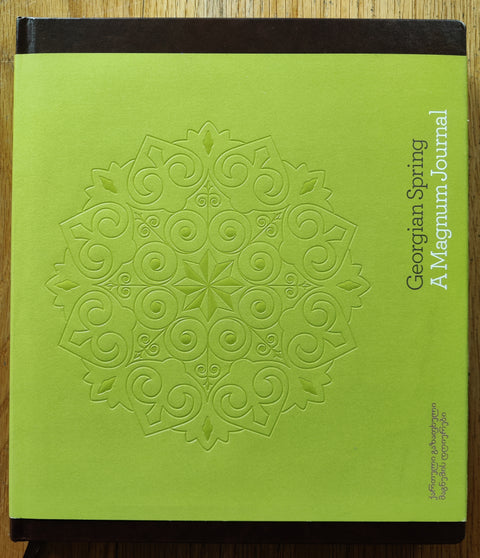 The photobook cover of Georgian Spring: A Magnum Journal In hardcover brown with a green bellyband.