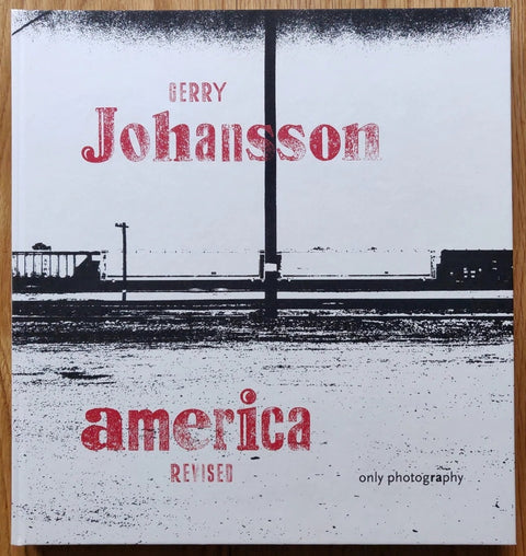 The photography book cover of America Revised by Gerry Johansson. Hardback in white with red text.