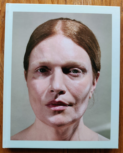 The photobook cover of Glitter in My Wounds by Adam Broomberg and Oliver Chanarin. In hardcover with a portrait of a woman.