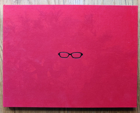 The photography book cover of Go There by Gen Sakuma. Hardback in red with glasses on the cover.