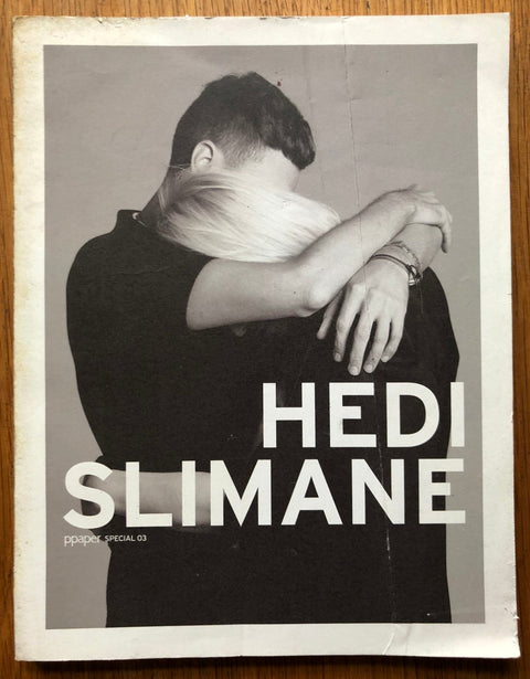 The photography book cover of Ppaper 03 by Hedi Slimane. Paperback with black and white image of two people hugging.