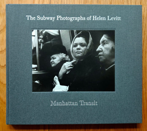 The photography book cover of Manhattan Transit - The Subway Photographs of Helen Levitt by Helen Levitt. Hardback in grey with image of people on the subway.
