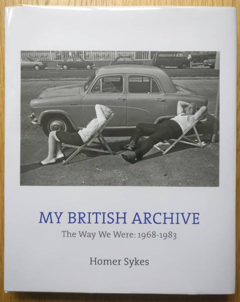 The photography book cover of My British archive The way we were 1968-1983 by Homer Skyes. Hardback white background with photo of people leaning on chairs.
