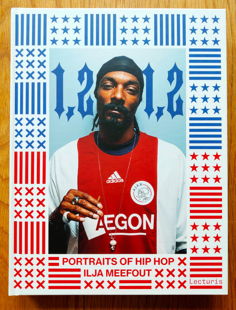 The photography book cover of 1,2 1,2: Portraits of Hip Hop by Ilja Meefout. Hardback with colours of the american flag on the cover surrounding snoop dog. Signed.