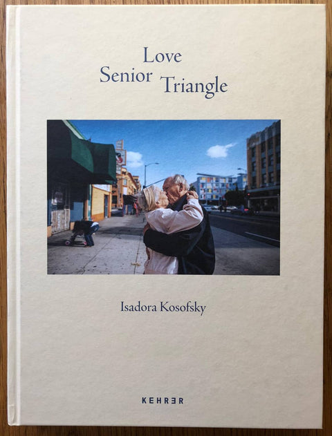The photography book cover of Senior Love Triangle by Isadora Kosofsky. Hardback in cream with image of an elderly couple kissing.