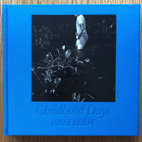 The photography book cover of Childhood Days by Issei Suda. Hardback with blue border. Signed.