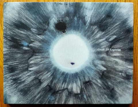 The photography book cover of Crash by JH Engstrom. Hardback with close up grey image of an eye with white pupil on the cover.