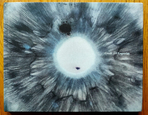 The photography book cover of Crash by JH Engstrom. Hardback with close up grey image of an eye with white pupil on the cover.