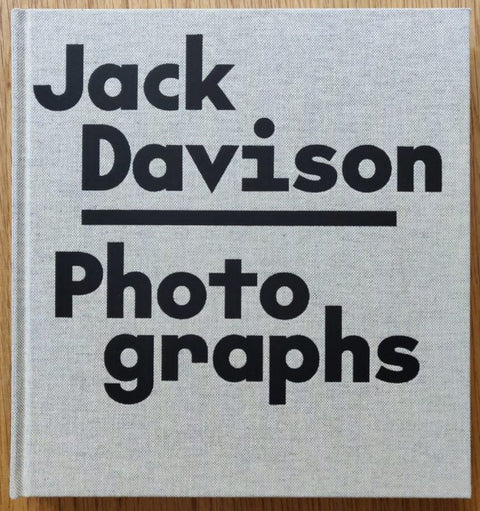 The photography book cover of Photographs by Jack Davidson. Hardback light grey cover with large black title and author.
