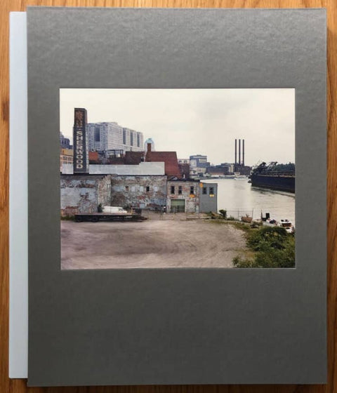 The photography book cover of Rust Belt by Jack Teemer. Hardback in grey with photo of industrial area surrounding a river.