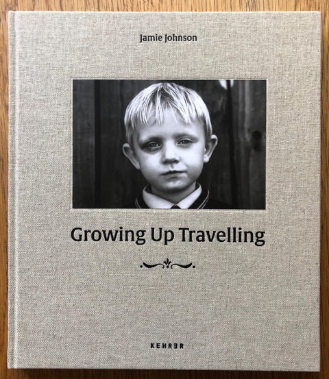 The photography book cover of Growing up Travelling by James Johnson. Hardback in beige with B&W image of a blonde boy.