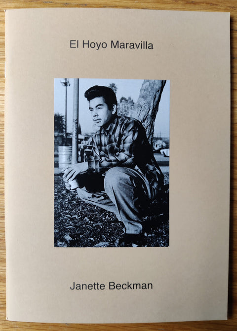The photography book cover of El Hoyo Maravilla by Janette Beckman. Paperback in beige with man crouching on the ground.