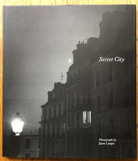 The photography book cover of Secret City by Jason Langer. Hardback with B&W image of buildings.