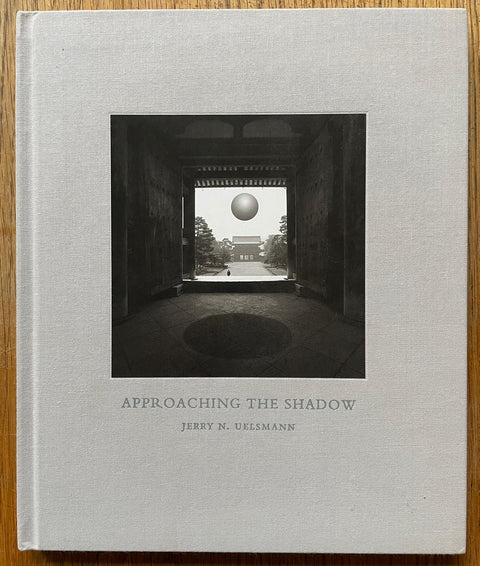 The photography book cover of Approaching the Shadow by Jerry N Uelsmann. Hardback in light grey. Signed.