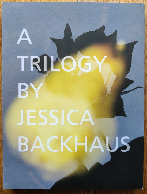 The photobook of A Trilogy by Jessica Backhaus. In softcover witha a silhouette of a flower.