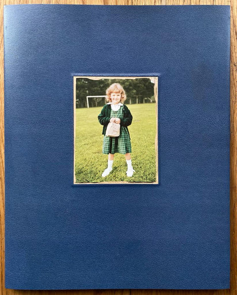 The photography book cover of Ruby Every Fall by Jim Goldberg. Hardback in navy blue with image of a small girl in a green dress on the cover. Signed.