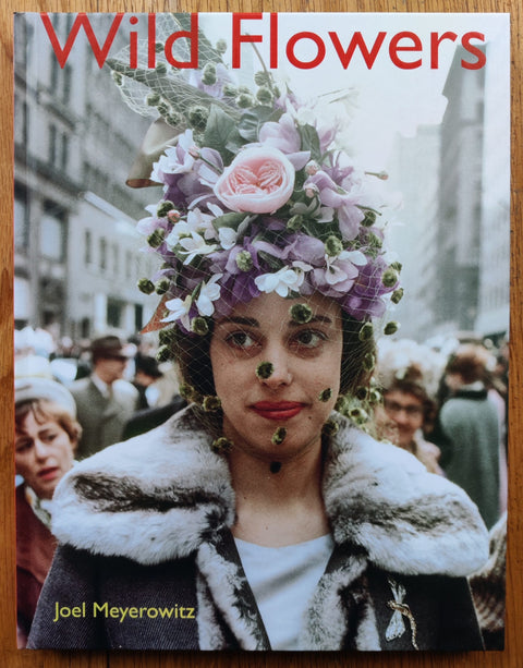 The photography book cover of Wild Flowers by Joel Meyerowitz. Hardback image of a girl with a flowery headress. Signed.