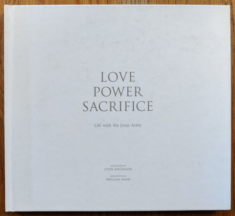 The photography book cover of Love Power Sacrifice: Life with the Jesus Army by John Angerson. Hardback in white, signed.