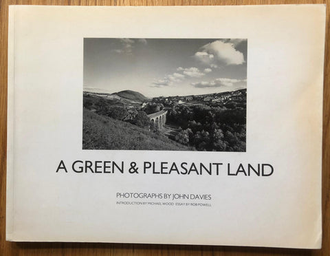 The photography book cover of A Green & Pleasant Land by John Davies. Paperback in white with B&W image of a bridge.