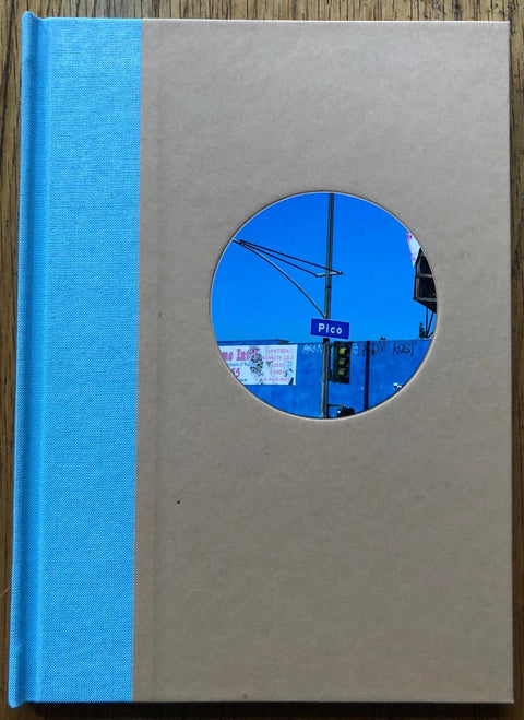 The photography book cover of Pico Boulevard by John Humble. Hardback with image of a sign saying Pico in the centre, light blue binding. Signed.