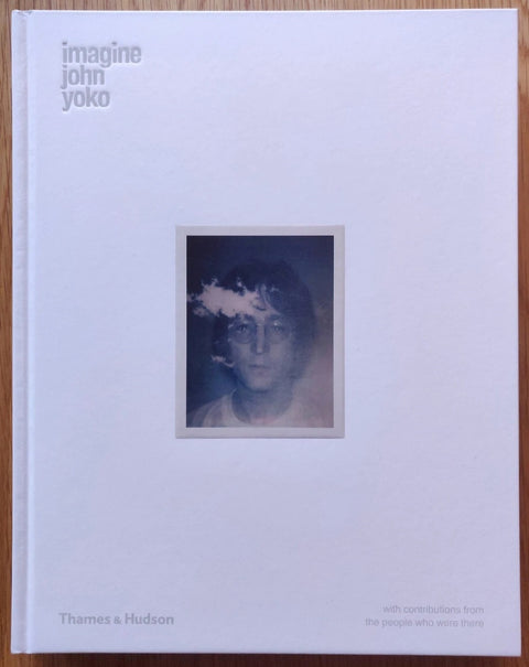 The photography book cover of Imagine by John Lennon and Yoko Ono. Hardback with a white background and image of John Lennon in the middle.