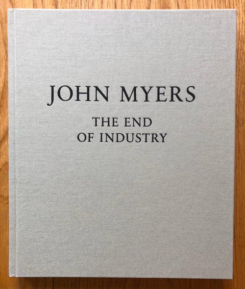 The photography book cover of The End of Industry by John Myers. Hardback in light grey. Signed.