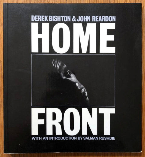 The photography book cover of Home Front by John Reardon. Paperback black with white text.