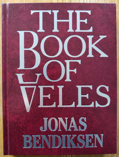 The photography book cover of The Book of Veles by Jonas Bendiksen. In hardcover dark red.