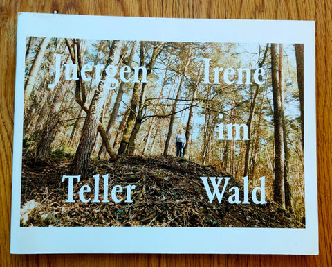 The photography book cover of Irene im Wald by Juergen Teller. Paperback in white with image of a person standing in the woods.