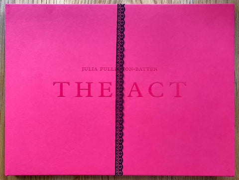 The photography book cover of The Act by Julia Fullerton-Batten. Hardback in bright pink with lace down the middle. Signed.