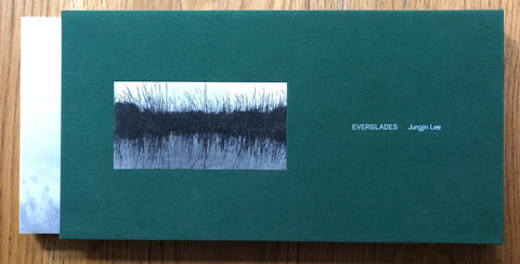 The photography book cover of Everglades by Jungjin Lee. Paperback with hardcover green slipcase. Signed.