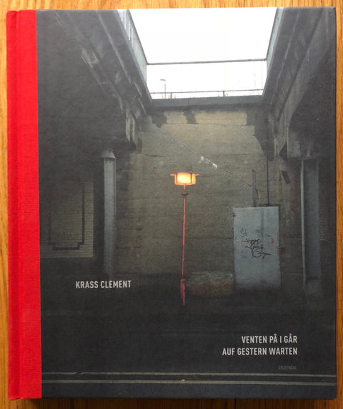 The photography book cover of Venten Pa I Gar by Krass Clement. Hardback with red spine.