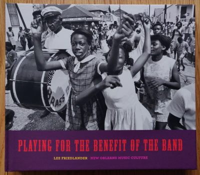 The photography book cover of Playing for the Benefit of the Band by Lee Friedlander. Hardback B&W image of a jazz parade.