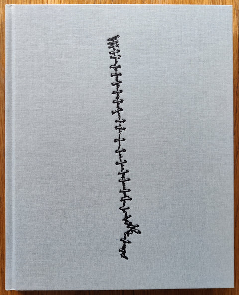 The photobook cover of Ending by Leif Sandberg. In hardcover light grey/blue. Signed.