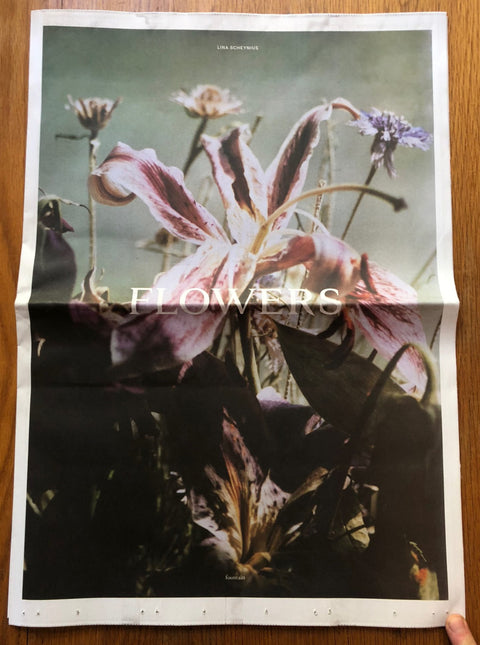The photography book cover of Flowers by Lina Scheynius. Newspaper style with photo of flowers on the cover.