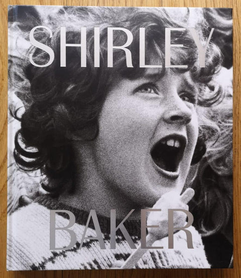 The photobook cover of Shirley Baker by Lou Stoppard Ed. Hardback with B&W image of a child shouting.