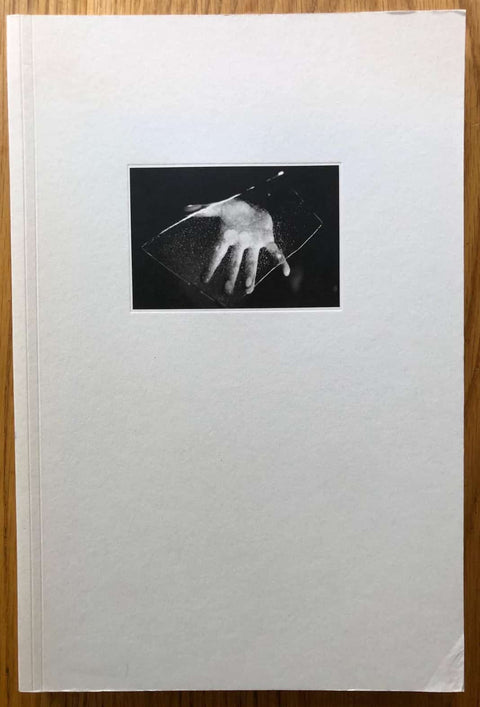 The photography book cover of Three Books by Michael Botman. Paperback in white with photo of a hand.