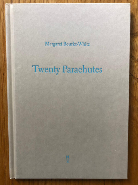 The photography book cover of Twenty Parachutes by Margaret Bourke-White. Hardback in light grey with light blue title. 