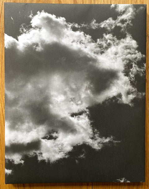 The photography book cover of Heaven is a Prison by Mark McKnight. Hardback in black with a cloud on the cover.