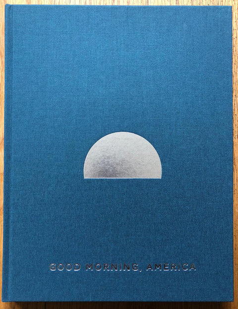 The photography book cover of Good Morning America (Volume Three) by Mark Power. Hardback in blue with silver detailing. Signed.