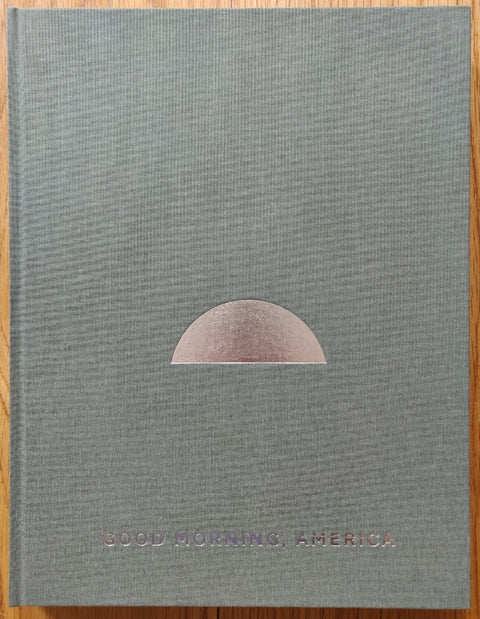 The photography book cover of Good Morning America (Volume Two) by Mark Power. Hardback in grey/green with silver/copper text.