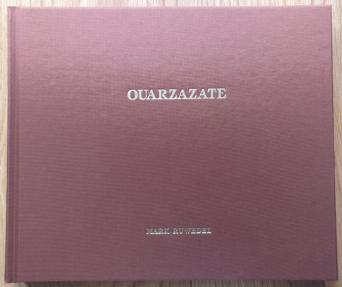 The photography book cover of OUARZAZATE by Mark Ruwedel. Hardback in dark red with silver text.
