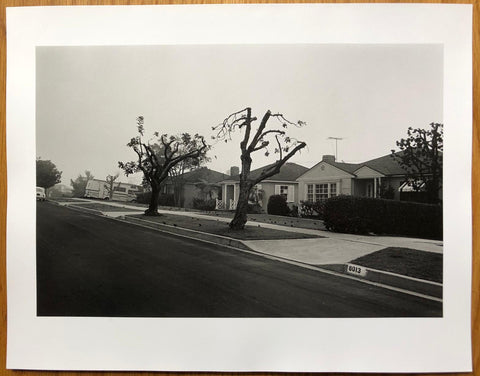 The print for photography book Angel City West 2 by Mark Steinmetz. B&W print of a suburban street. Hardback in yellow, signed.
