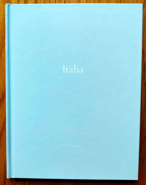 The photography book cover of Italia by Mark Steinmetz. Hardback in light blue. Signed and numbered.